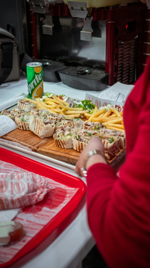 a person in a kitchen preparing food on a cutting board, with fries, in a subway, community celebration, tourist photo