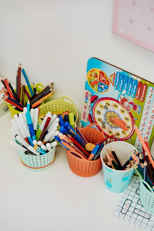 a desk topped with lots of different colored pencils, a child's drawing, collection product, on a white table, album, kids toys