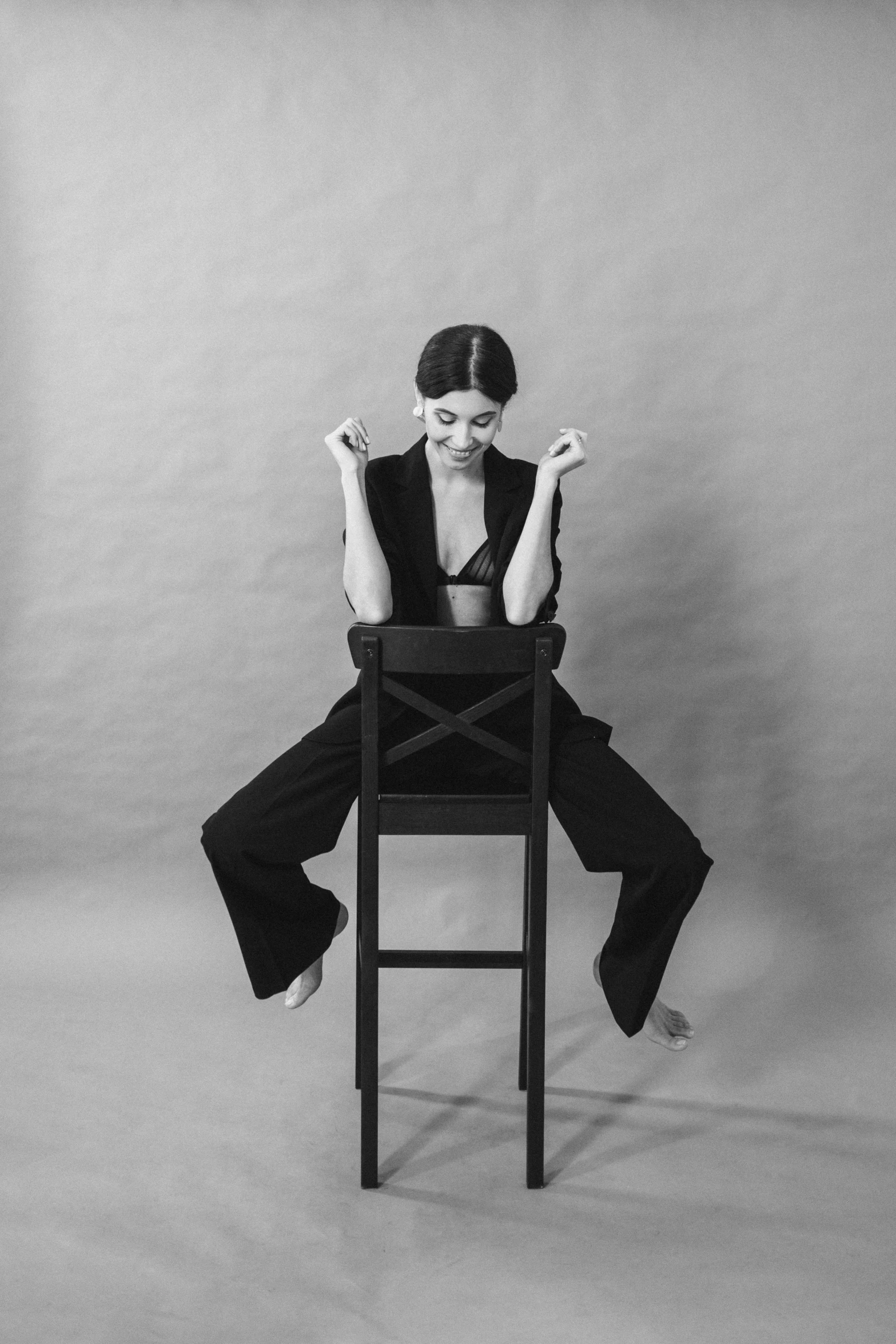 a black and white photo of a woman sitting on a chair, inspired by Marina Abramović, pexels contest winner, lucy hale, playful pose, alexandra fomina, kendall jenner