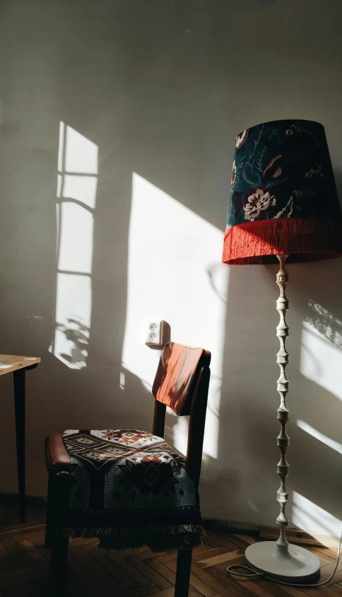 a lamp sitting on top of a table next to a chair, unsplash, sun puddle, color photograph, eclectic, studio photo