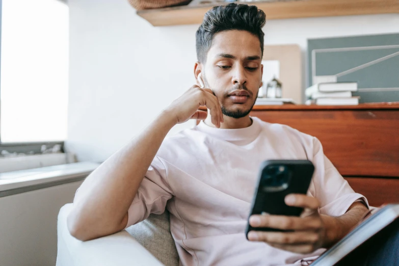 a man sitting on a couch using a cell phone, trending on pexels, looking distracted, avatar image, aged 2 5, instagram post