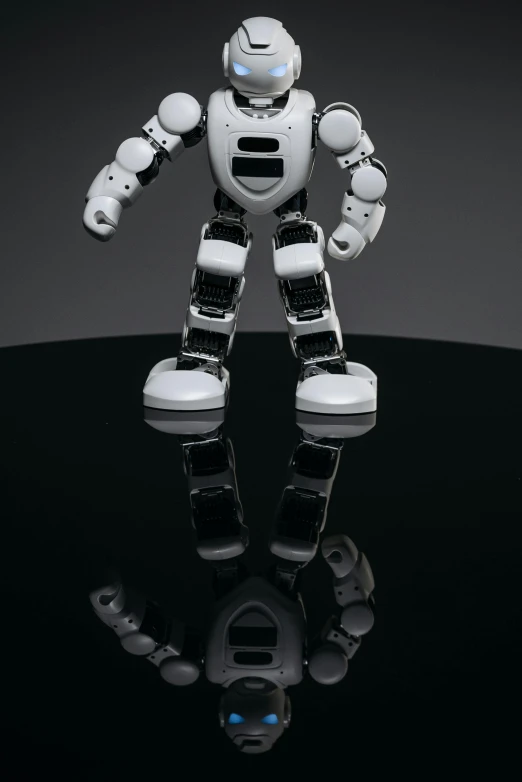 a robot that is standing on a table, inspired by Robert Zünd, unsplash, highly reflective surface, promo image, frontal shot, baymax