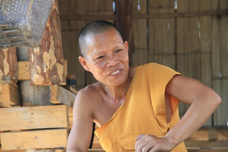 a man standing in front of a pile of bananas, a portrait, inspired by Nam Gye-u, pexels contest winner, portrait of monk, profile image, a wooden, older woman