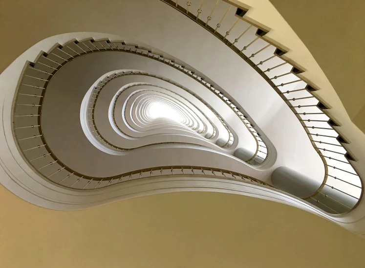 a spiral staircase in the middle of a building, inspired by André Kertész, unsplash contest winner, bauhaus, john pawson, vienna secession, ignant, golden curve structure