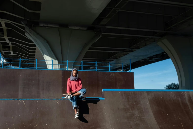 a man riding a skateboard up the side of a ramp, a portrait, hurufiyya, sitting under bridge, hijab, large scale photo, 15081959 21121991 01012000 4k