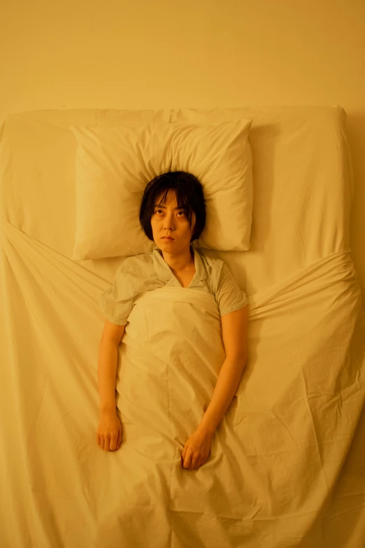 a woman laying in a bed with a pillow, inspired by Nan Goldin, serial art, sui ishida with black hair, in a movie still cinematic, worried, circle