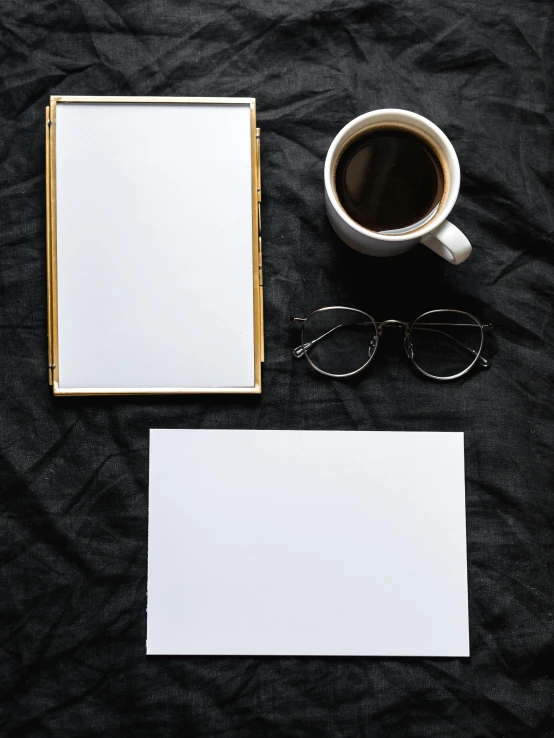 a cup of coffee, notepad and eyeglasses on a black cloth, a picture, by Adam Rex, postminimalism, square pictureframes, unfinished canvas, gold framed, unsplash contest winning photo