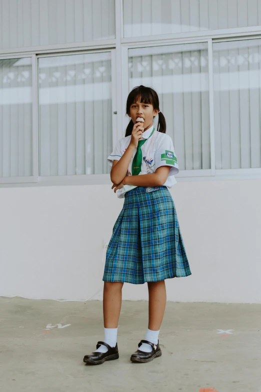 a girl in a school uniform talking on a cell phone, inspired by Ni Yuanlu, pexels contest winner, standing microphones, white shirt and green skirt, cindy avelino, patriotism