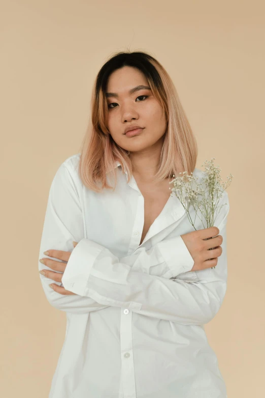 a woman in a white shirt holding a bunch of flowers, inspired by Ruth Jên, trending on unsplash, minimalism, two color hair, asian descent, long sleeves, product introduction photo