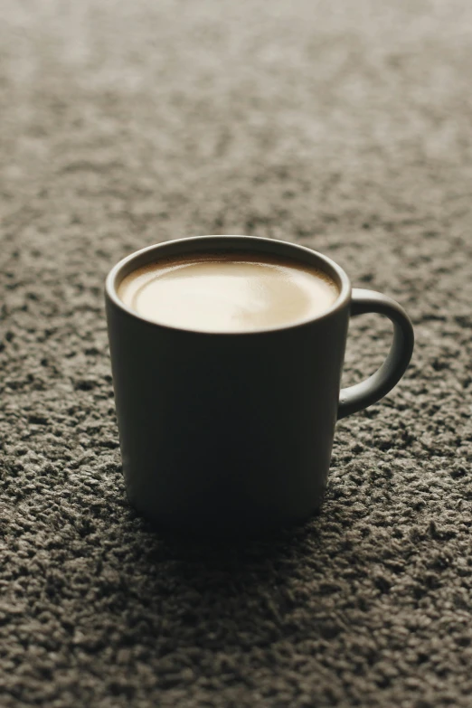 a cup of coffee sitting on top of a carpet, by James Morris, unsplash, photorealism, medium format. soft light, promo image, grey, made of glazed