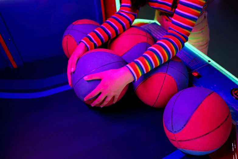 a person sitting on a ball in front of a mirror, inspired by Howard Arkley, dribble, interactive art, glowing fingers, colourful close up shot, softplay, playing basketball