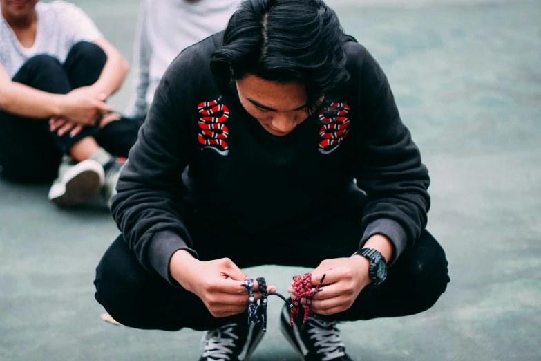 a group of people sitting on top of a tennis court, a cross stitch, pexels contest winner, visual art, techwear clothes, black shirt with red suspenders, thawan duchanee, profile image
