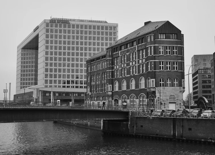 a black and white photo of a bridge over a river, inspired by David Chipperfield, pexels contest winner, bauhaus, tenement buildings, viewed from the harbor, palast der republik in berlin, 2 0 0 0's photo