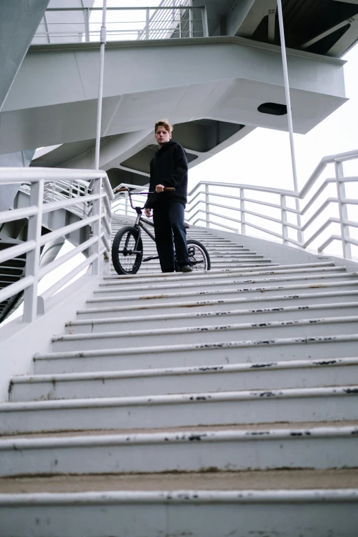 a man standing on top of a set of stairs, cycling!!, very very low quality picture, docked at harbor, yung lean