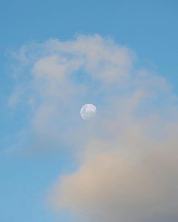 a plane flying in the sky with the moon in the background, unsplash, postminimalism, fluffy pastel clouds, foggy photo 8 k, profile image, colour photograph