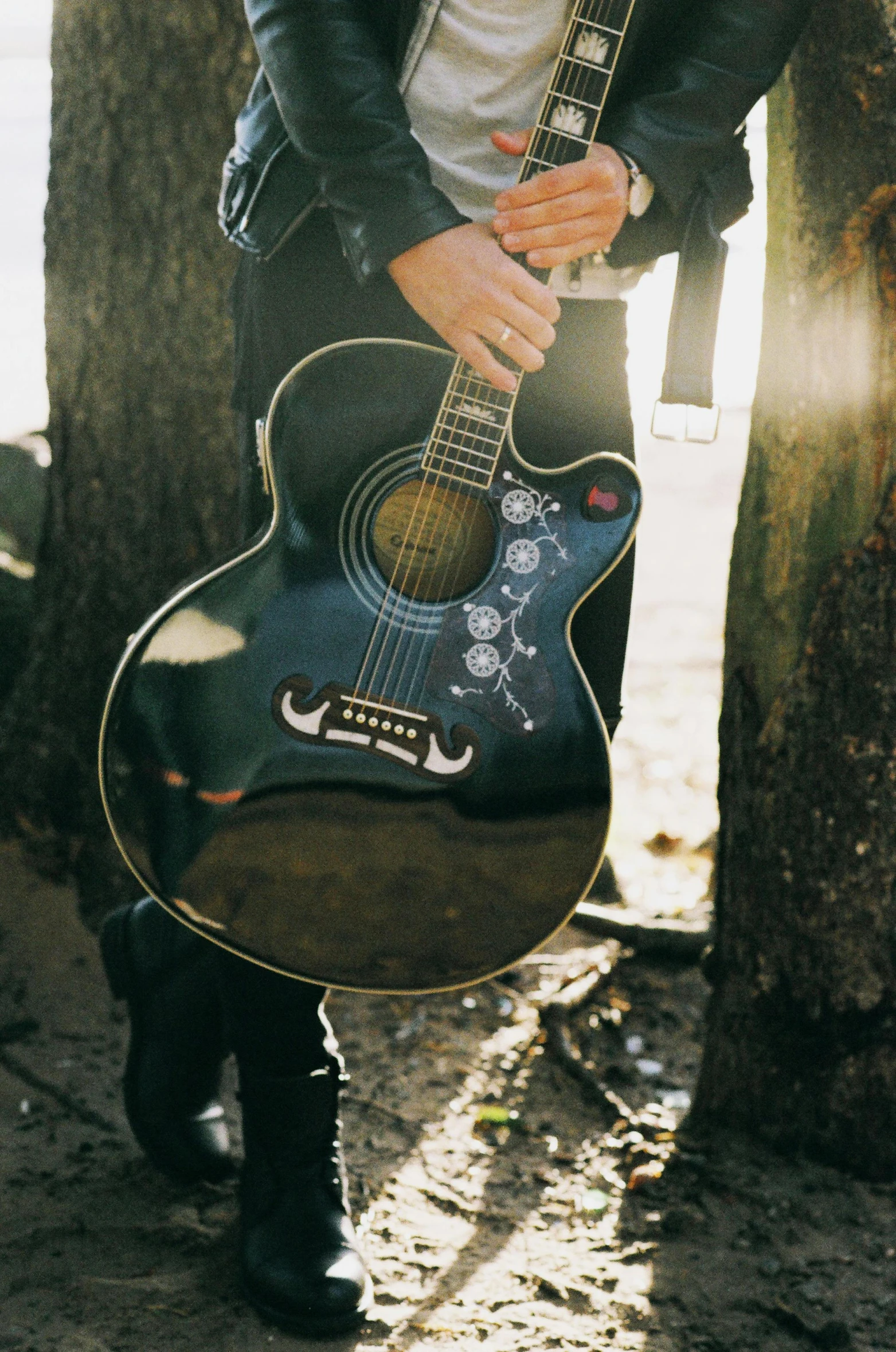 a man standing next to a tree holding a guitar, an album cover, pexels contest winner, detail shot, icon, cowboy, hot topic