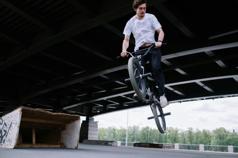 a man flying through the air while riding a bike, inspired by Seb McKinnon, pexels contest winner, realism, yung lean, overpass, felix englund, lighting her with a rim light