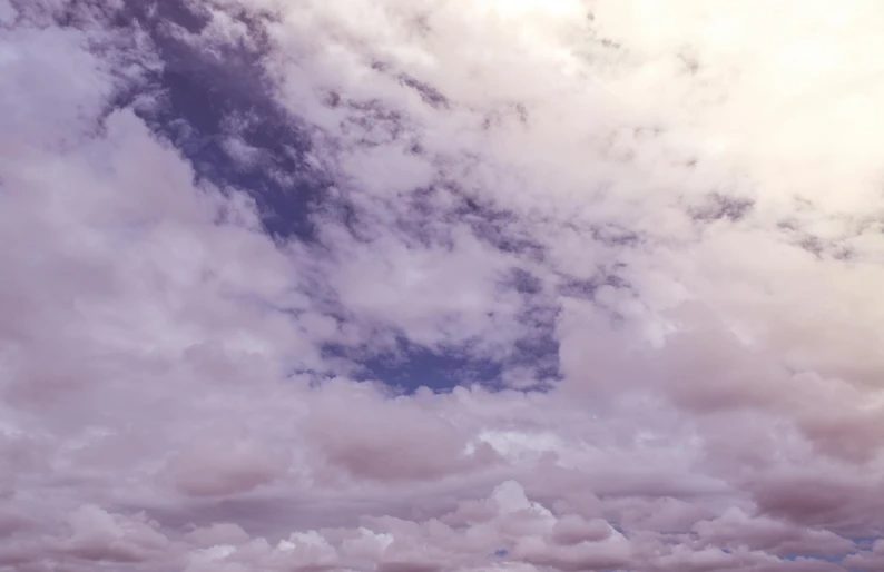 a man flying a kite on top of a lush green field, an album cover, unsplash, romanticism, dark purple clouds, cotton candy clouds, 4 k cinematic still, panorama view of the sky