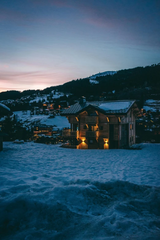 a house sitting on top of a snow covered slope, unsplash contest winner, renaissance, evening lights, huts, lush surroundings, exterior