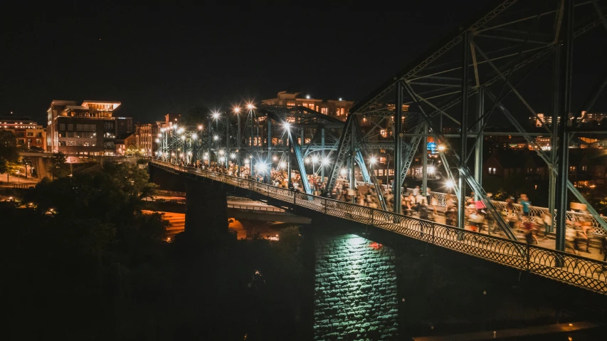 a bridge over a body of water at night, by Dan Frazier, unsplash contest winner, in a massive cavernous iron city, warm summer nights, wide high angle view, paisley