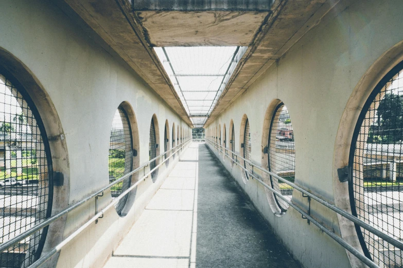 a long walkway with lots of windows next to each other, inspired by Thomas Struth, unsplash contest winner, brutalism, pewdiepie selfie at a bridge, portholes, high walled tunnel, high-angle