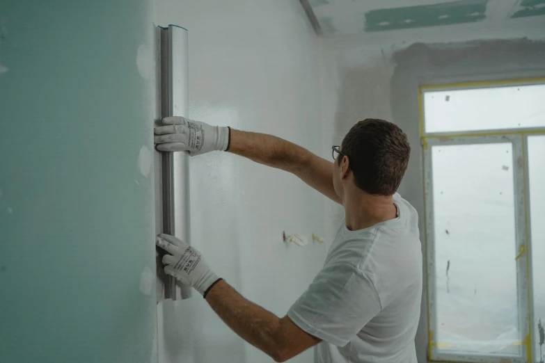 a man that is standing in front of a wall, repairing the other one, profile image, suspended ceiling, white concrete