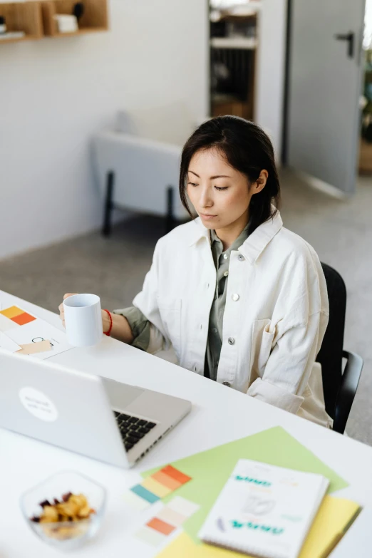 a woman sitting at a table with a laptop, trending on pexels, ethnicity : japanese, office clothes, gif, engineer