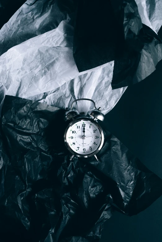 a black and white photo of an alarm clock, a black and white photo, by Adam Marczyński, pexels contest winner, vanitas, wearing a plastic garbage bag, paper crumpled texture, thumbnail, nigth
