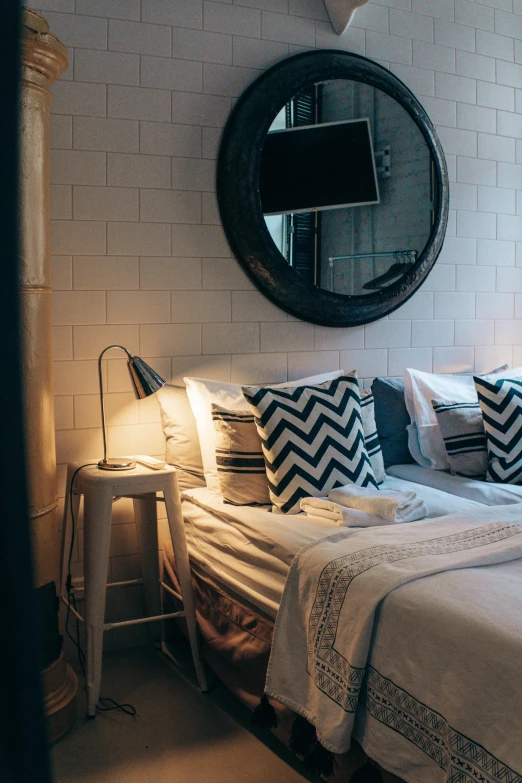 a bed room with a neatly made bed and a mirror, by Jan Tengnagel, unsplash, “ iron bark, white pillows, multiple lights, patterns