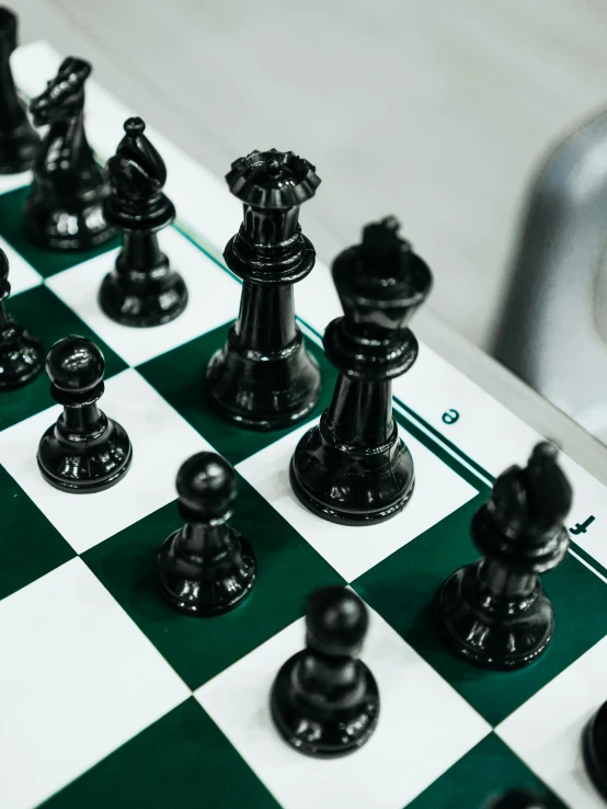 black and white chess pieces on a green and white checkered board, by Carey Morris, trending on unsplash, instagram story, pair of keycards on table, dark green color scheme, 💣 💥💣 💥