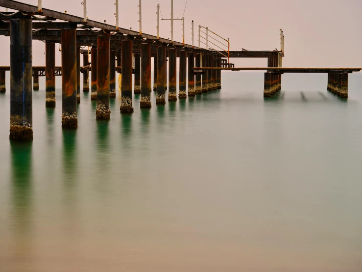 a long pier in the middle of a body of water, pexels contest winner, australian tonalism, industrial colours, ((rust)), medium format, soft light - n 9