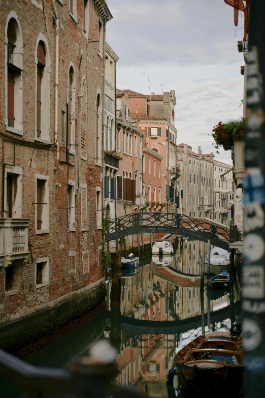 a canal filled with lots of boats next to tall buildings, by Canaletto, unsplash contest winner, renaissance, street signs, 1999 photograph, bridge, color image