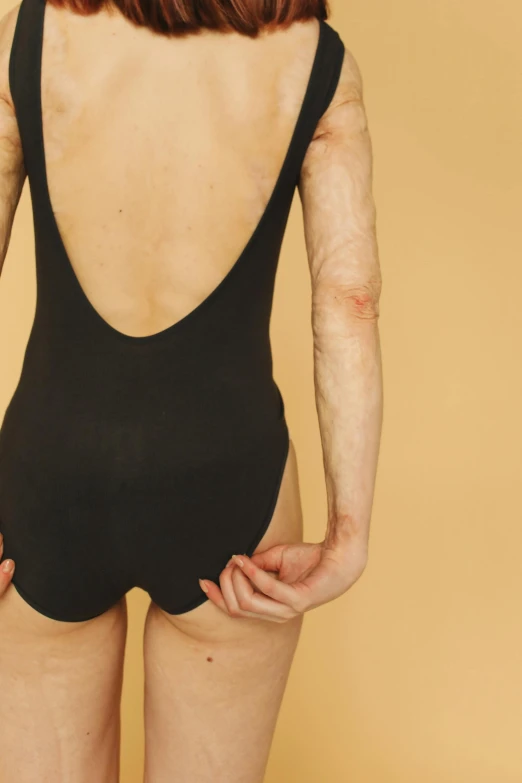 the back of a woman in a black bodysuit, an album cover, by Ellen Gallagher, trending on pexels, emaciated, bandages, human-skin pelt, circa 1 9 7 9