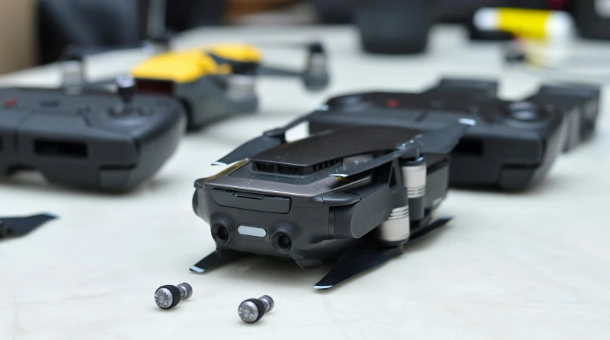 a couple of remote controls sitting on top of a table, uav, micro detailing, black and yellow scheme, micro machines