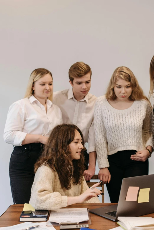 a group of people standing around a table with a laptop, profile image, modelling, multiple stories, girls