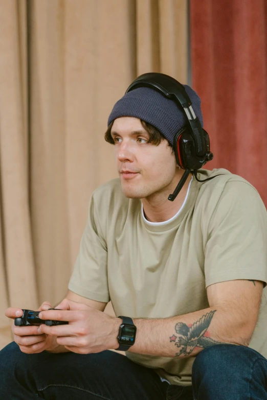 a man wearing headphones playing a video game, inspired by Seb McKinnon, looking defiantly at the camera, orelsan, he is wearing a hat, concerned