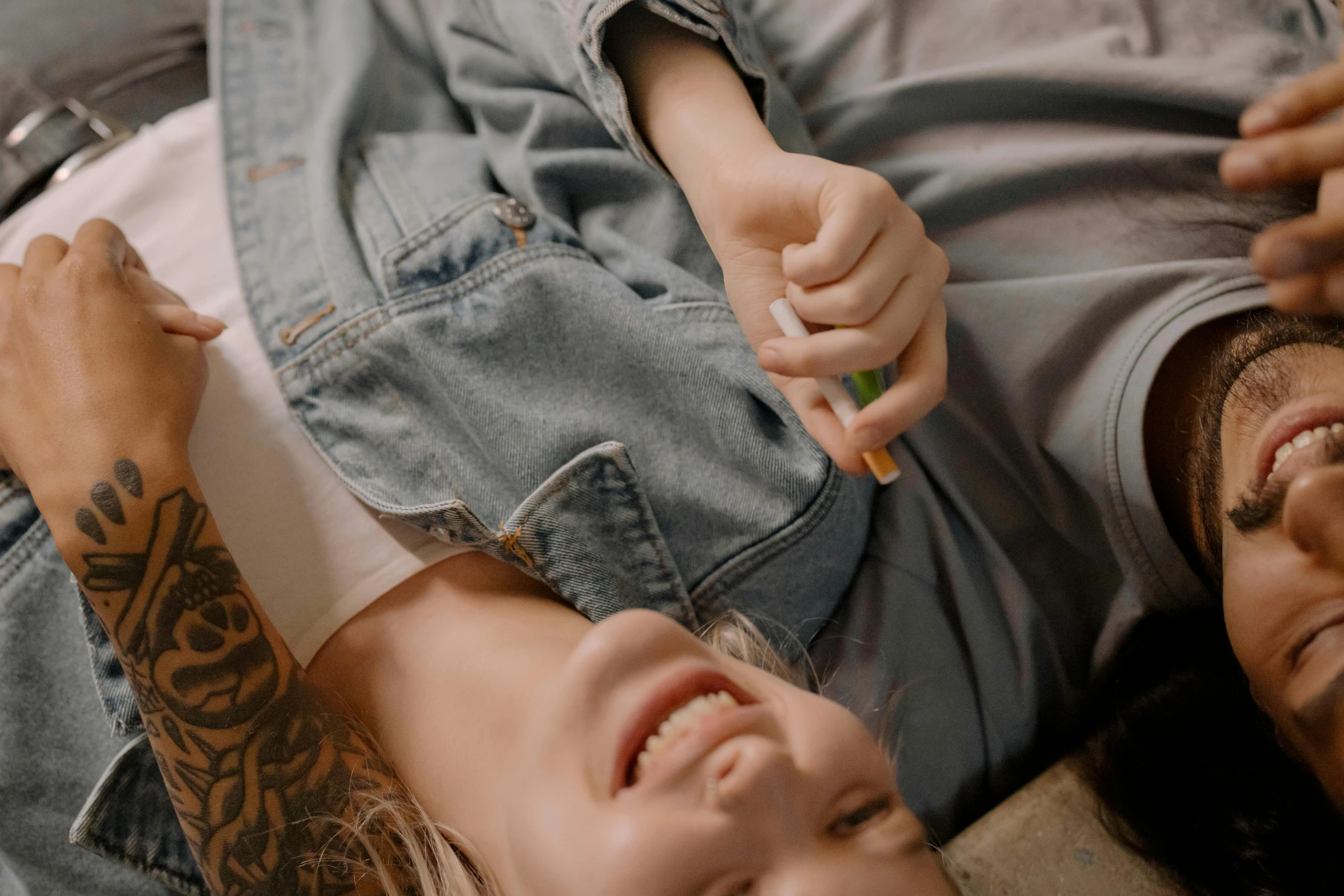 a man and a woman laying next to each other, trending on pexels, hyperrealism, kid named finger, she is laughing, wearing a shirt and a jean, holding pencil