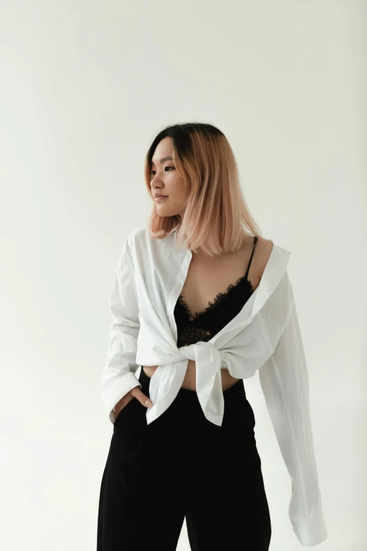 a woman in a white shirt and black pants, inspired by Feng Zhu, trending on unsplash, bralette, white backdrop, half asian, lily frank