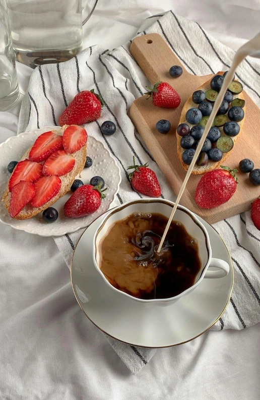 a white plate topped with fruit next to a cup of coffee, red + black + dark blue + beige, strawberries, bread, background image