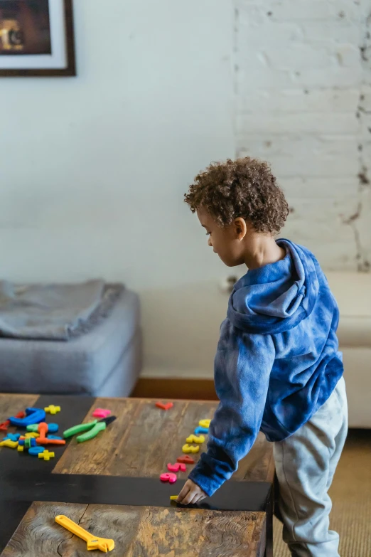 a little boy standing on top of a wooden table, playing board games, soft surfaces, looking her shoulder, gen z