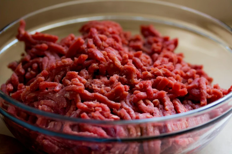 a bowl filled with meat sitting on top of a table, ground meat, caucasian, shredded, up close image