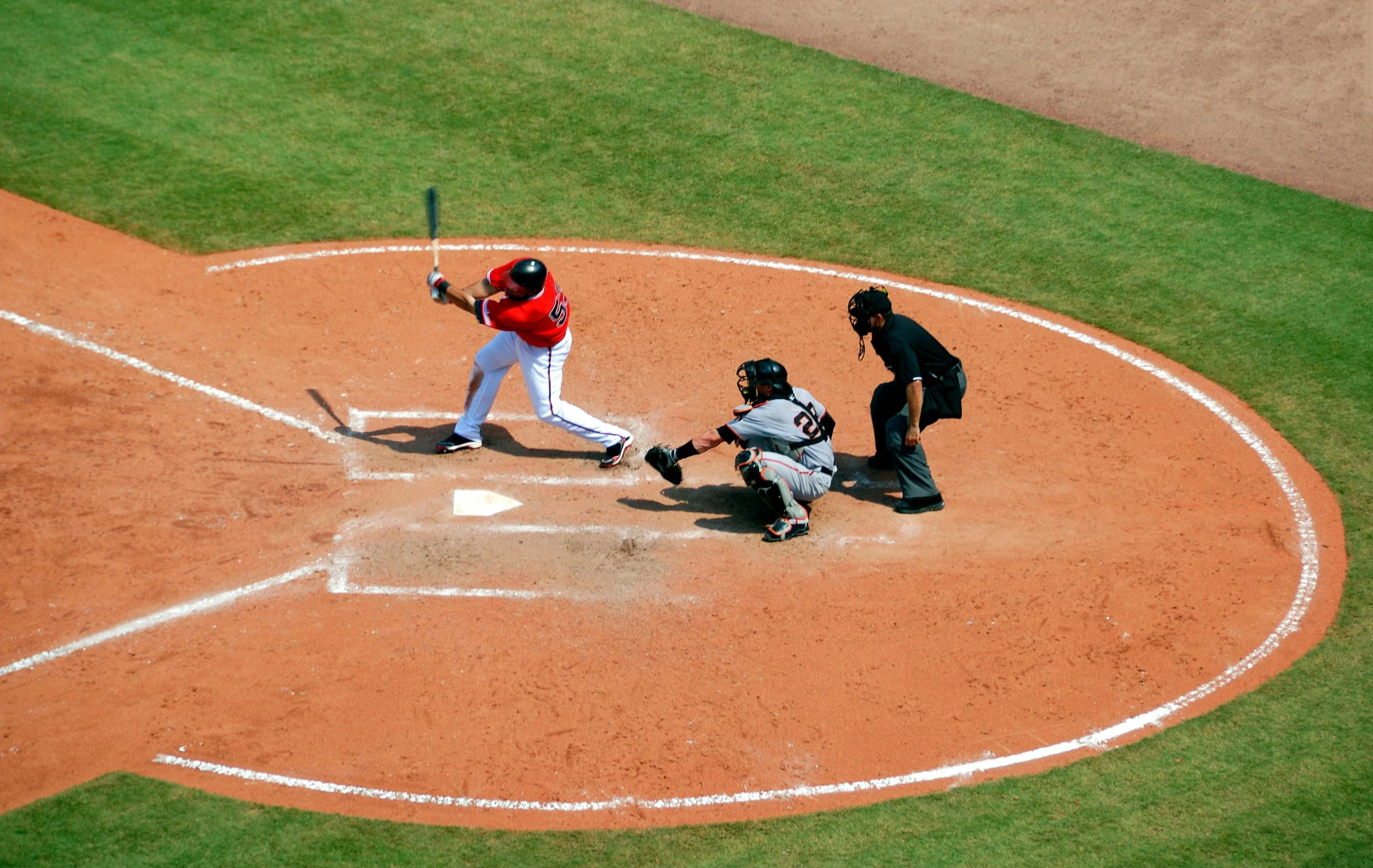 a baseball player swinging a bat at a ball, pexels contest winner, birds eye view, square, circle pit, red and black color scheme