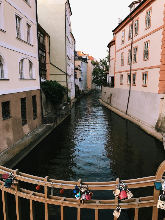 a river running through a city next to tall buildings, by Emma Andijewska, in legnica, slide show, low quality photo, grain”