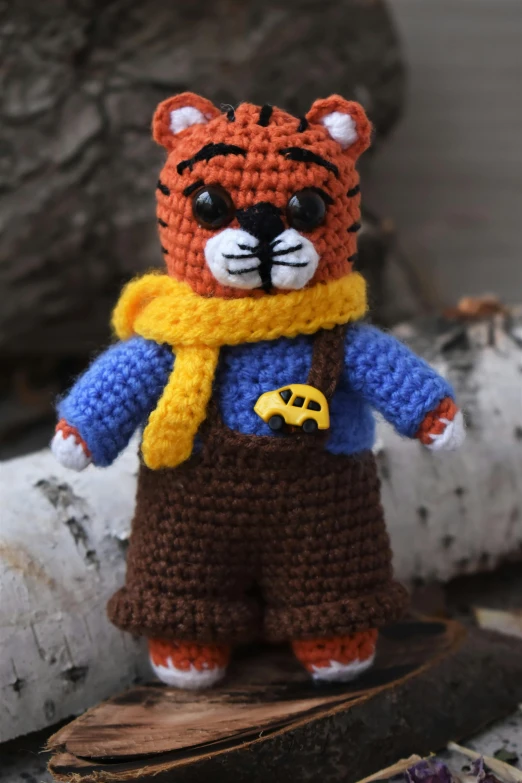 a close up of a stuffed animal on a log, inspired by Wes Anderson, reddit contest winner, multicolored crocheted cats, nick wilde, thumbnail, avatar image