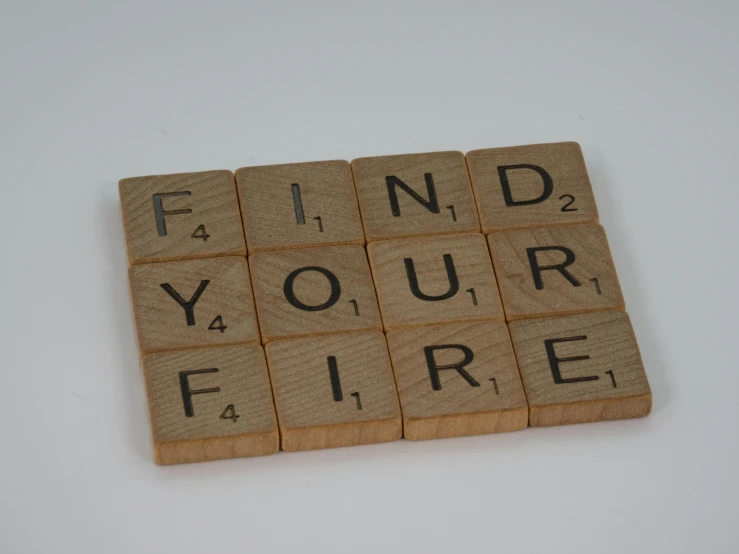 a scrabble with the words find your fire written on it, by Emma Andijewska, figuration libre, on grey background, woodfired, - 12p, firefighter