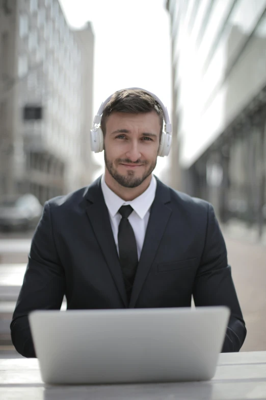 a man sitting in front of a laptop wearing headphones, trending on pexels, portrait of a man in a suit, meme format, urban setting, caucasian