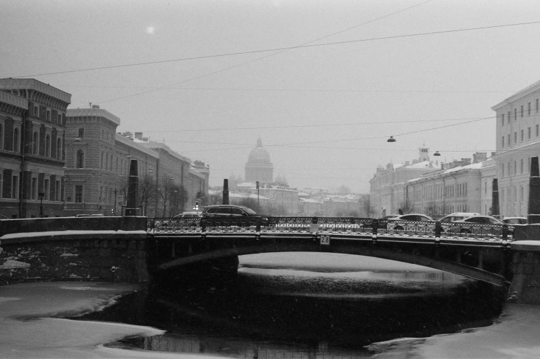 a black and white photo of a bridge over a river, a black and white photo, by Sergei Sviatchenko, city snowing with a lot of snow, saint petersburg, 2 0 0 0's photo, anna nikonova