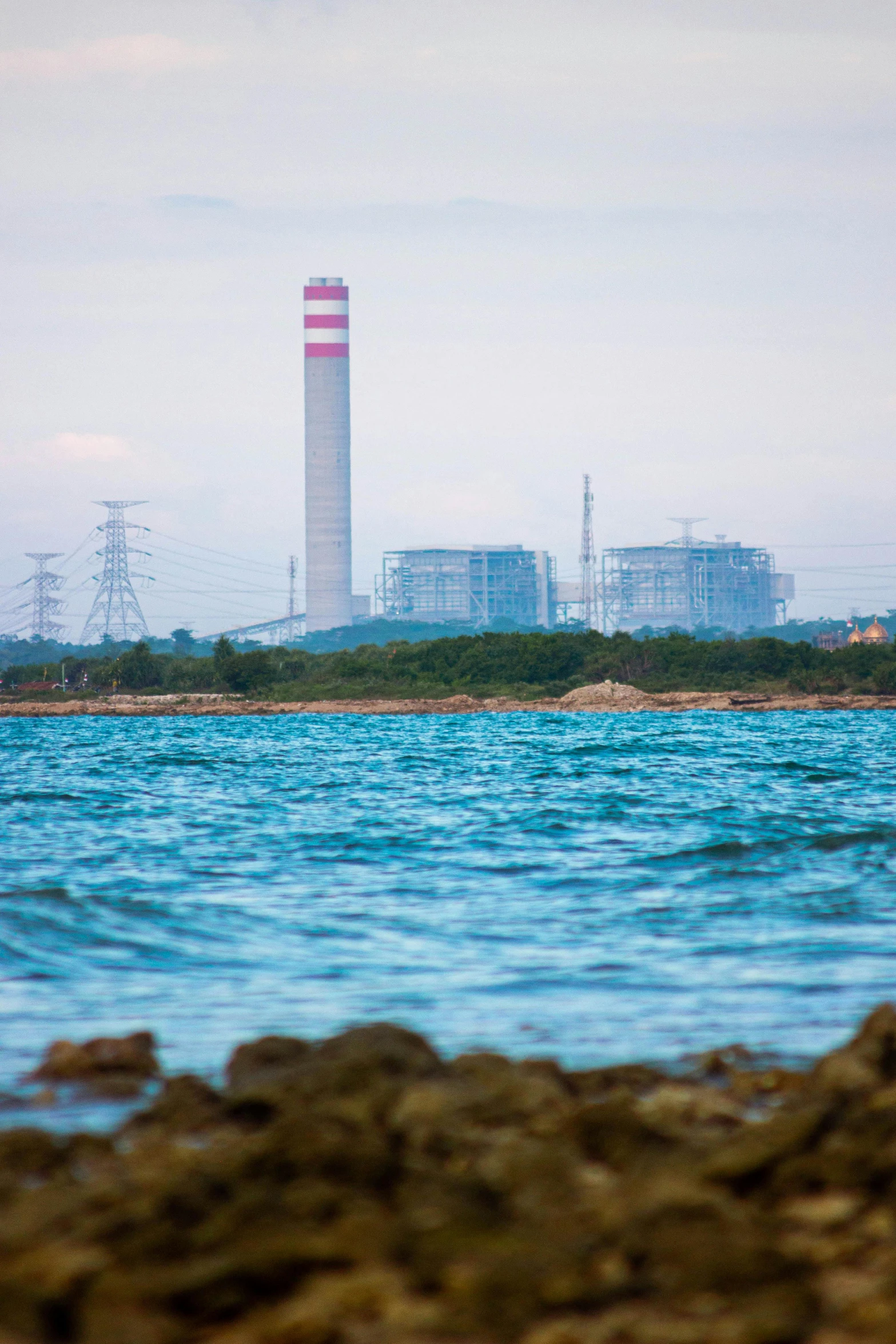 a large body of water with a power plant in the background, an album cover, croatian coastline, guangjian, promo image, multiple stories