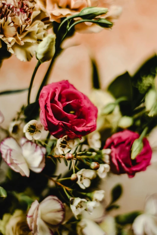 a bouquet of flowers sitting on top of a table, by Elsie Few, trending on unsplash, romanticism, fine details. red, dynamic closeup, delicate details, set in 1 8 5 0