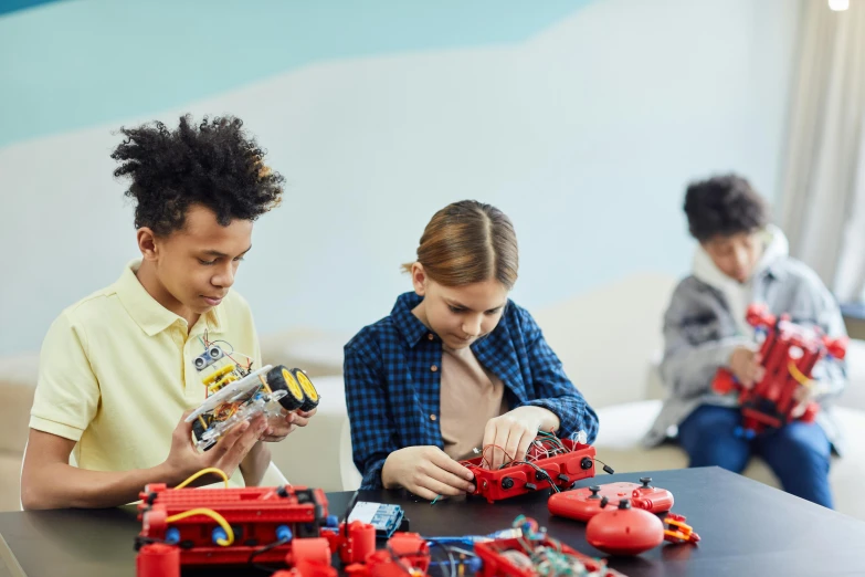 a couple of people that are sitting at a table, kids toys, red and black robotic parts, keter class, cars